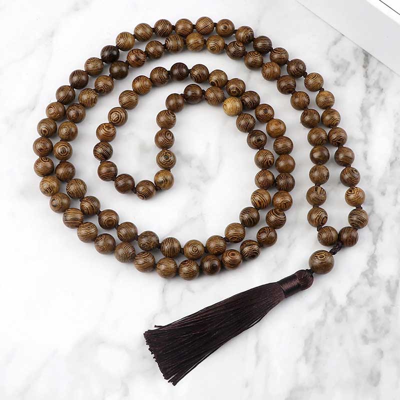 Mala 108 perles bois de santal avec pompon vue de dessus posé sur une plaque de marbre gris et blanc Kaosix