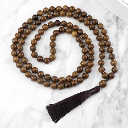 Mala 108 perles bois de santal avec pompon vue de dessus posé sur une plaque de marbre gris et blanc Kaosix
