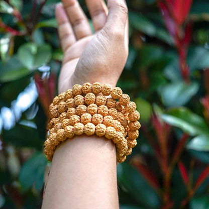 Mala 108 perles graines de Rudraksha Symbole Om (Aum) au poignet dune femme Kaosix