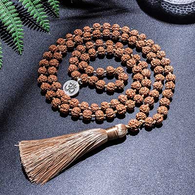 Mala 108 perles graines de Rudraksha Symbole Om (Aum) enroulé sur sol gris foncé Kaosix