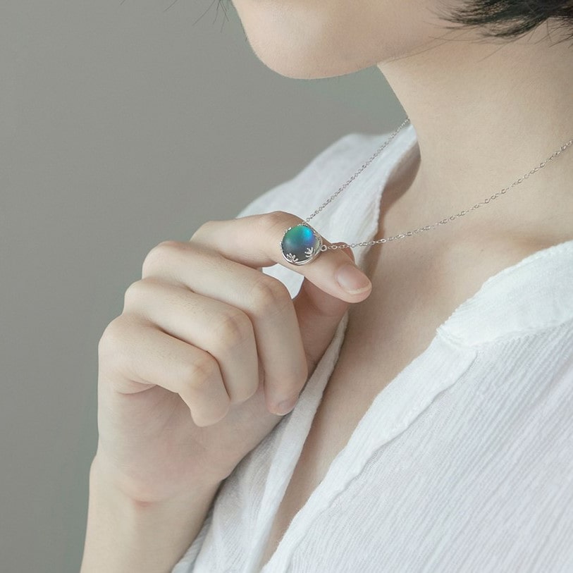 Pendentif Aurore Boréale perle de cristal bleu foncé couronne argentée au cou d'une femme Kaosix