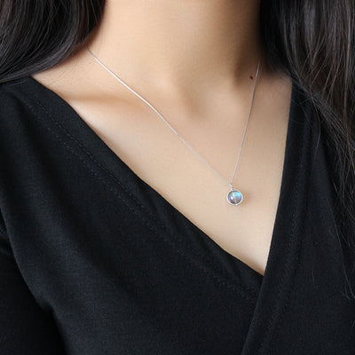 petit pendentif labradorite argent portée par jeune femme gros plan sur décolleté noir