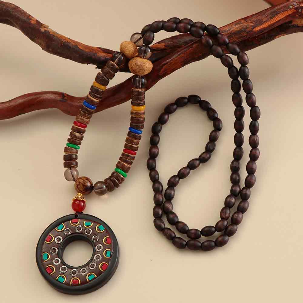 Pendentif et collier ethnique népalais Cercle en bois posé sur une branche en bois avec un fond beige Kaosix