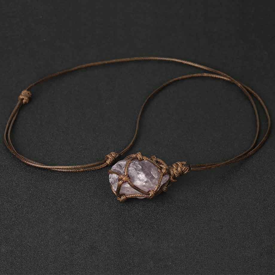 Pendentif pierre brute cordon wrap améthyste sur un tapis gris foncé Kaosix