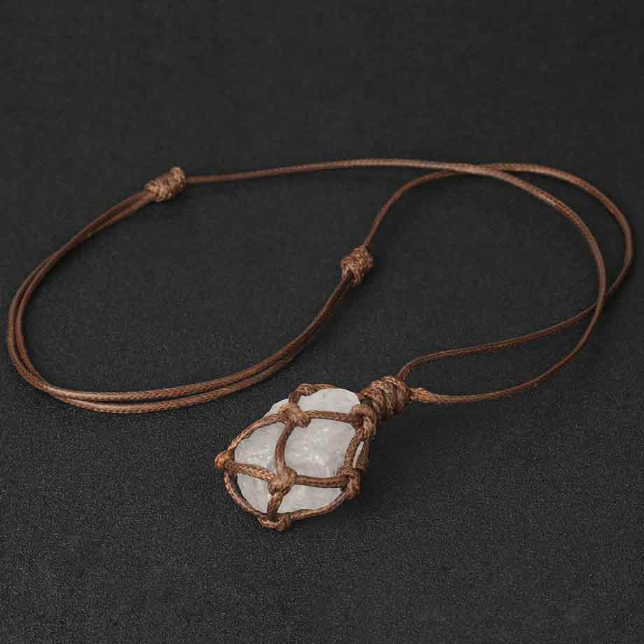 Pendentif pierre brute cordon wrap cristal de roche sur un tapis gris foncé Kaosix