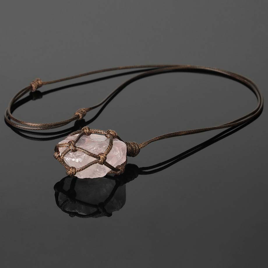 Pendentif pierre brute cordon wrap quartz rose sur une surface vitrée grise sombre Kaosix