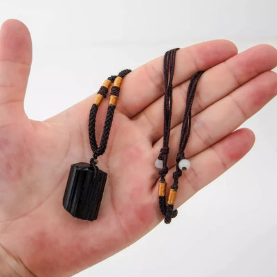 Pendentif tourmaline noire pierre brute pour homme enroulé autour de la main d'un homme Kaosix