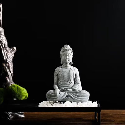 Statue Bouddha assis appel à la terre posé sur des galets de pierre avec fond noir Kaosix