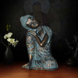 Statue Bouddha assis penseur cuivre bleu ciel sur table en bois et fond noir Kaosix