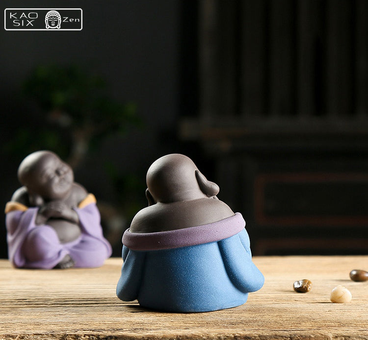 2 Petits Bouddhas rieurs robe bleue et robe violette assis face à face sur planchette en bois
