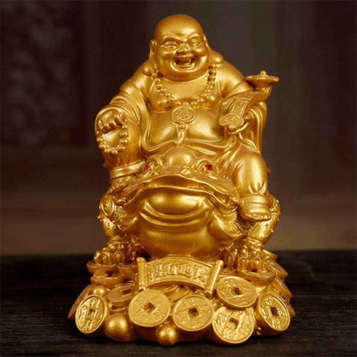 Statue bouddha rieur doré sur grenouille à trois pattes posé sur une table en bois foncé et fond flou Kaosix