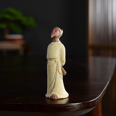Statue chinoise personnage historique Li Bai Li Bo ou Taibai posée sur une table en bois laqué sombre avec un fond flou Kaosix