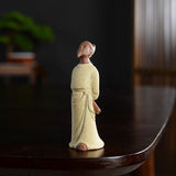 Statue chinoise personnage historique Li Bai Li Bo ou Taibai posée sur une table en bois laqué sombre avec un fond flou Kaosix