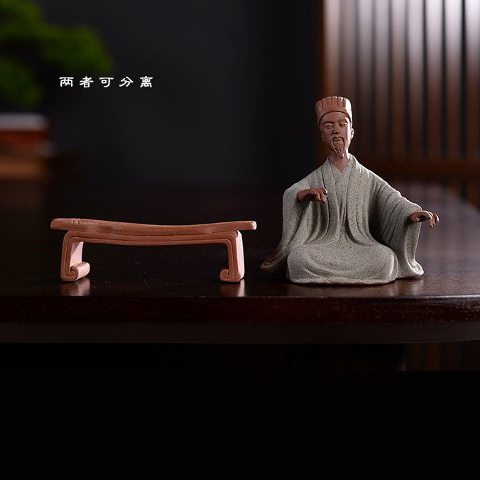Statue chinoise personnage historique Zhuge Liang Kong Ming avec son instrument de musique  posée sur une table en bois laqué sombre avec un fond flou Kaosix
