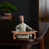 Statue chinoise personnage historique Zhuge Liang Kong Ming posée sur une table en bois laqué sombre avec un fond flou Kaosix