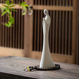 Statue moine debout blanc Namaste sur une table en bois avec porte en bois en fond Kaosix
