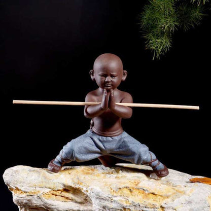 Statuette bouddhiste moine Shaolin bâton couleur bleu debout sur un rocher et sur un fond noir Kaosix