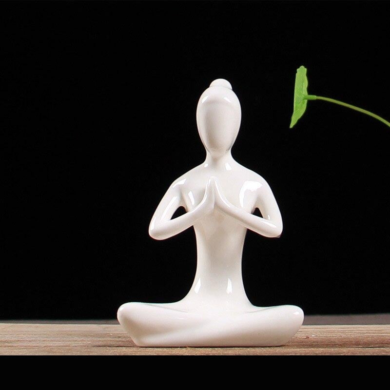 Statuette yoga femme pose du lotus anjali mudra posee sur table fond noir Kaosix