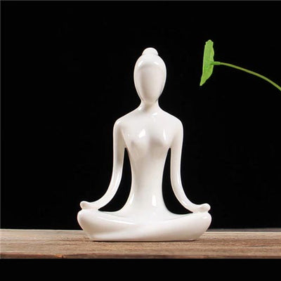 Statuette yoga femme position du lotus mains sur genoux posee sur table fond noir Kaosix
