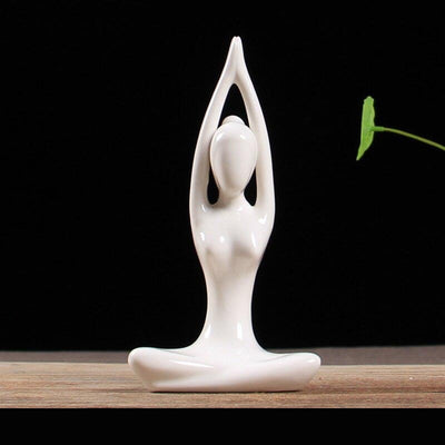 Statuette yoga femme posture du lotus bras leves posee sur table fond noir Kaosix
