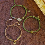 Trois bracelets tressés perles en jade de Hetian posés sur un tapis marron vue de dessus Kaosix