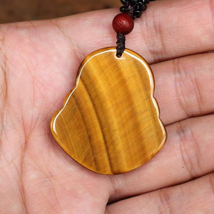 Vude de dos du Collier pendentif Bouddha Rieur en Œil de Tigre posé sur la peaume d'une main d'homme Kaosix