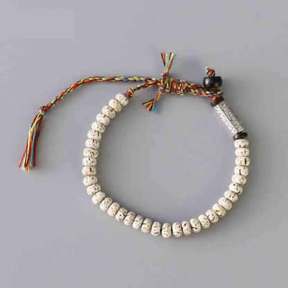 Vue aerienne du bracelet tibétain graine de bodhi mantra sur une table grise Kaosix