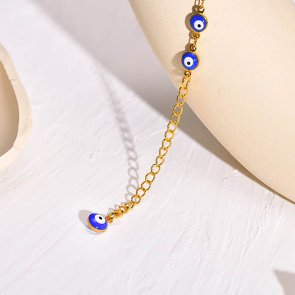 Vue en gros plan du Bracelet de cheville en perles de nazar boncuk bleu avec amulette khamsa posé sur une assiette beige Kaosix