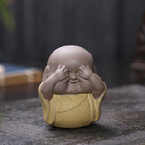 Les 3 moines de la sagesse sagesse robe jaune sur table en bois kaosix