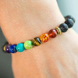 bracelet guerison des 7 chakras en pierres de lave sur poignet de femme