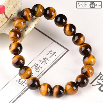 Bracelet protection œil de tigre posé sur support céramique et papier blanc
