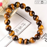 Bracelet protection œil de tigre posé sur support céramique et papier blanc