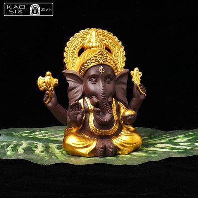 Statue de Ganesh doré posé sur feuille de bananier