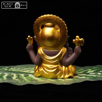 Statue de Ganesh doré vue de dos posé sur feuille de bananier