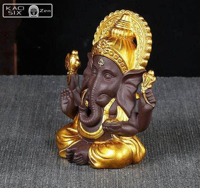 Statue de Ganesh doré posé sur un tapis